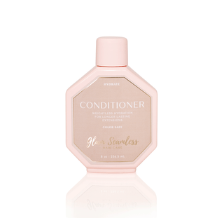 A bottle of glow smooches conditioner designed for hair extensions, showcasing its vibrant packaging and nourishing formula.