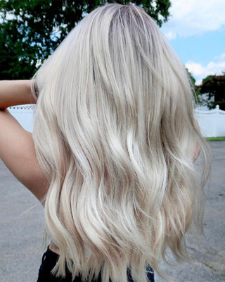 A woman with long blonde hair, enhanced by Glam Seamless hair extensions.