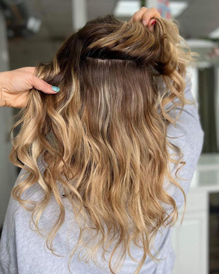 The back of the head of a woman with bahamian balayage hair extensions at a salon.