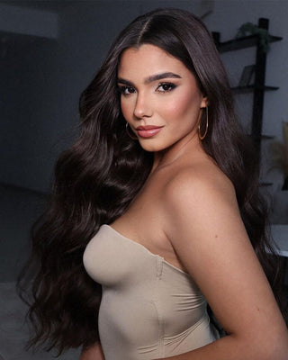 A woman with Dark brown Glam Seamless hair extensions smiling and posing.